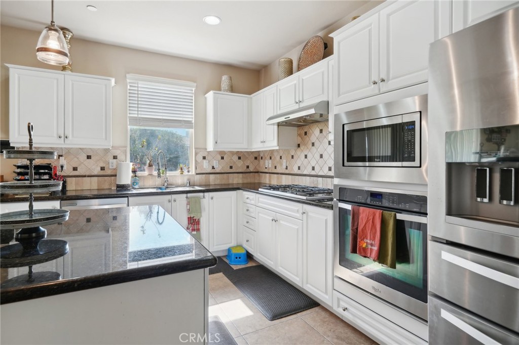 29259 Bouris Drive Menifee, CA 92584 - Photo 14 of 56 a kitchen with stainless steel appliances white cabinets a sink a stove a refrigerator and microwave