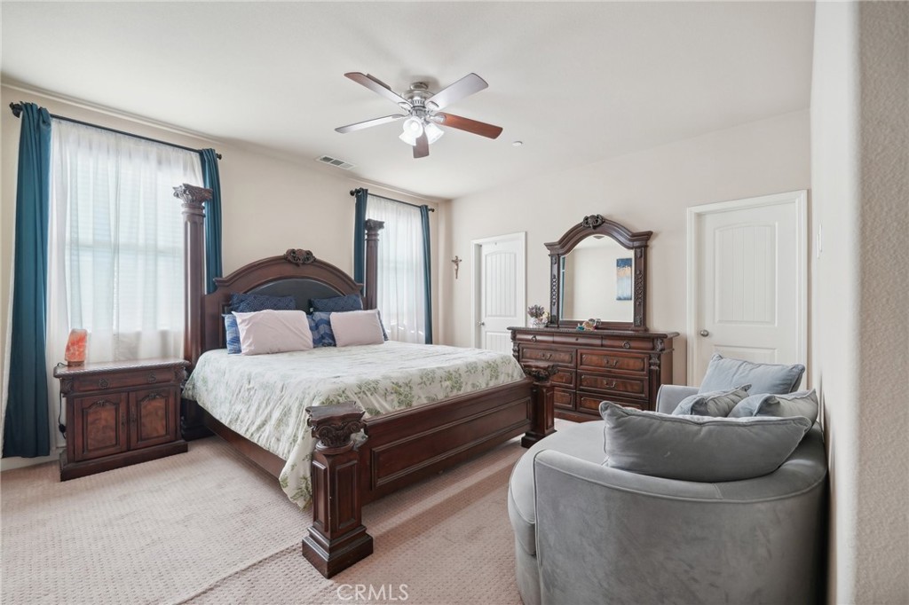 29259 Bouris Drive Menifee, CA 92584 - Photo 26 of 56 a bedroom with a bed and a chandelier