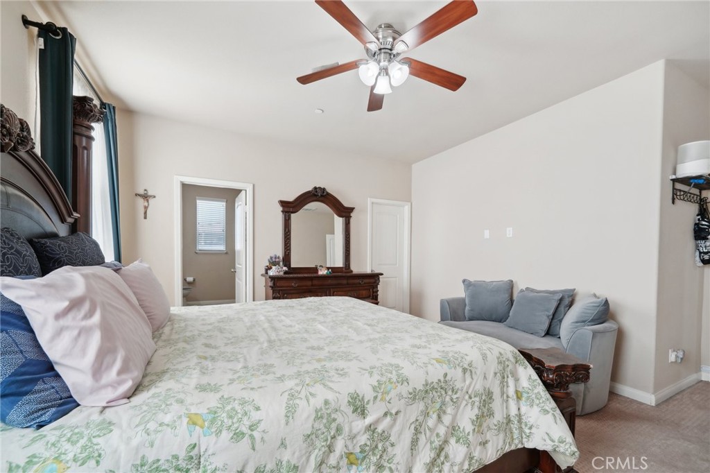 29259 Bouris Drive Menifee, CA 92584 - Photo 27 of 56 a bedroom with a large bed and a chandelier