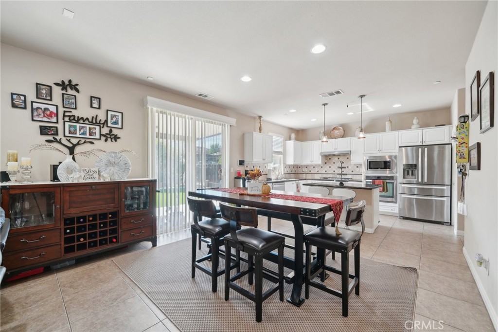 29259 Bouris Drive Menifee, CA 92584 - Photo 9 of 56 a kitchen with a dining table chairs and white appliances
