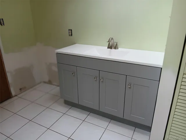 a bathroom with a granite countertop toilet and a sink