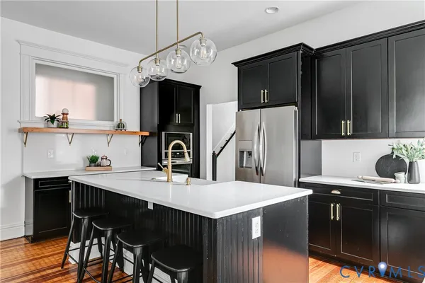 a kitchen with stainless steel appliances a kitchen island sink refrigerator and cabinets