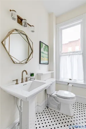 a bathroom with a sink a toilet and a mirror
