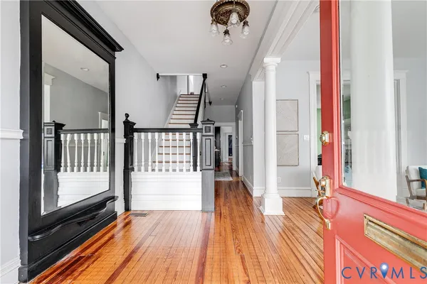 a view of a hallway with wooden floor and staircase