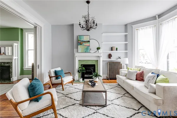 a living room with furniture a chandelier and a fireplace