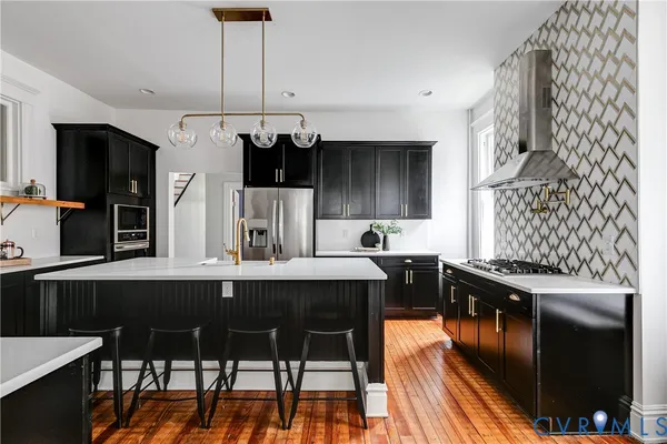 a kitchen with stainless steel appliances kitchen island granite countertop a sink and cabinets