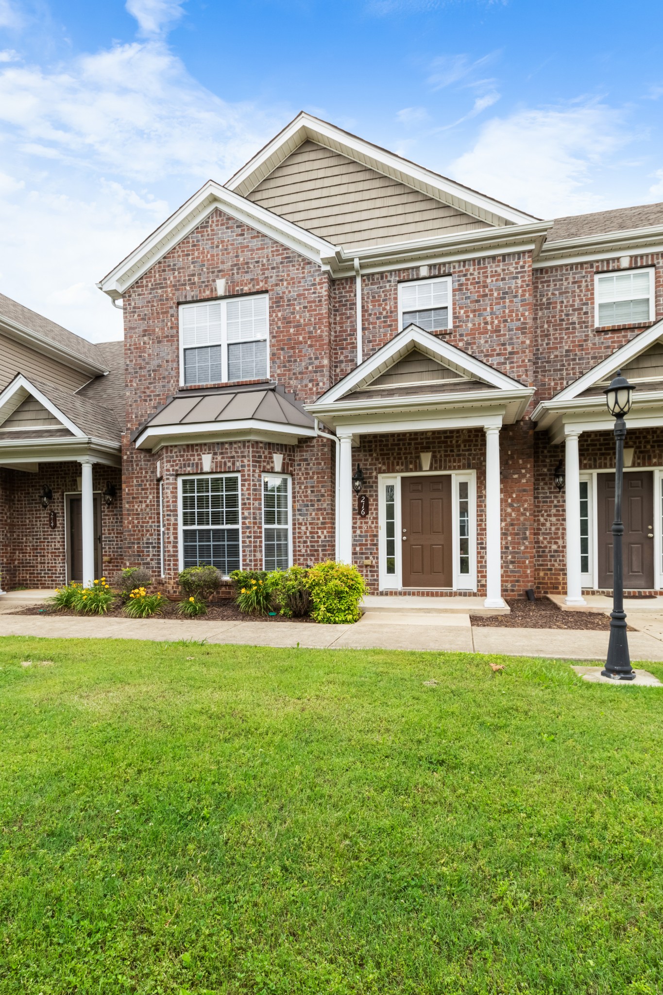 front view of a brick house with a yard