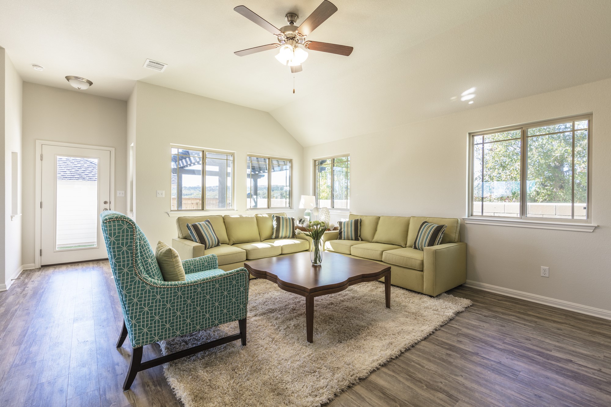2725 Hopi Path Leander, TX 78641 - Photo 23 of 30 A comfortable living space boasts a vaulted ceiling and rich hardwood-style flooring, perfect for gatherings.