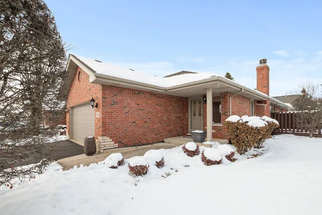 a front view of a house with a yard covered in snow