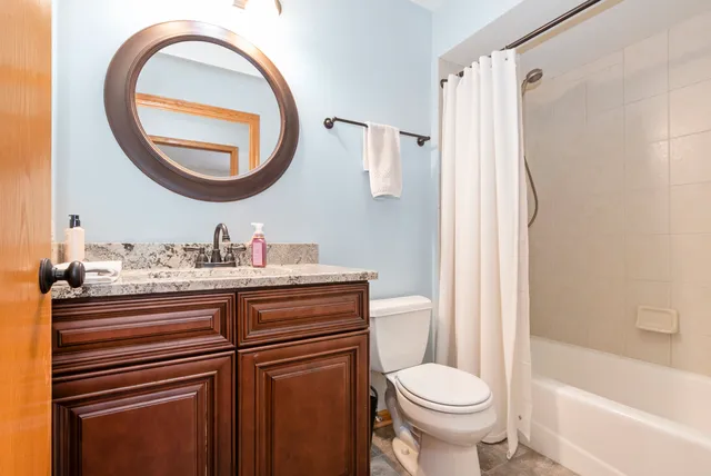 a bathroom with a granite countertop toilet sink and a mirror