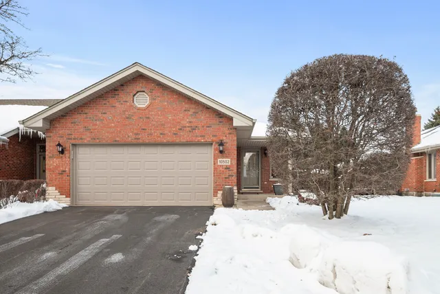 a front view of house with yard covered in snow