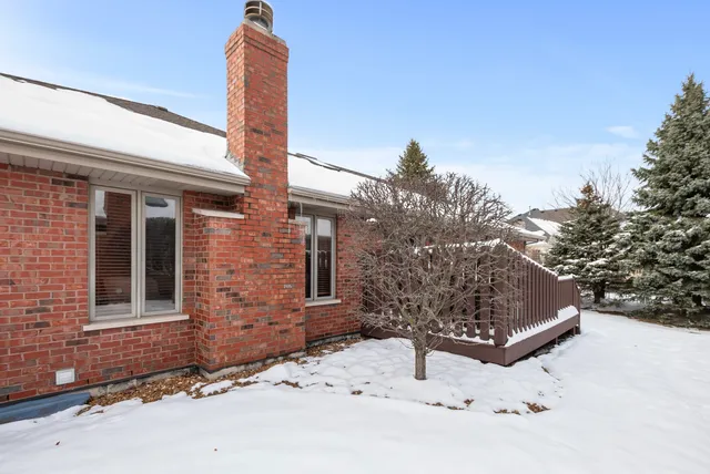 a front view of a house with a yard covered with snow