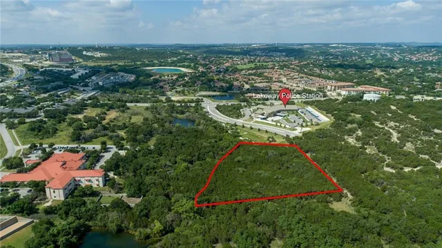 an aerial view of residential houses with outdoor space and trees