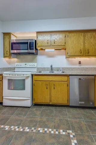 a view of a kitchen with stainless steel appliances granite countertop a stove and a sink
