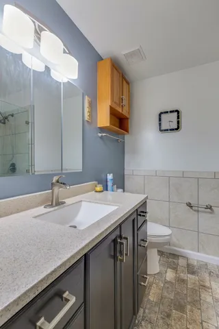a bathroom with a sink a toilet and mirror