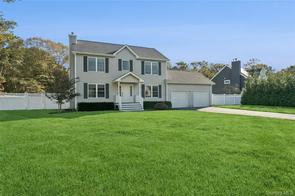a front view of a house with a garden and yard