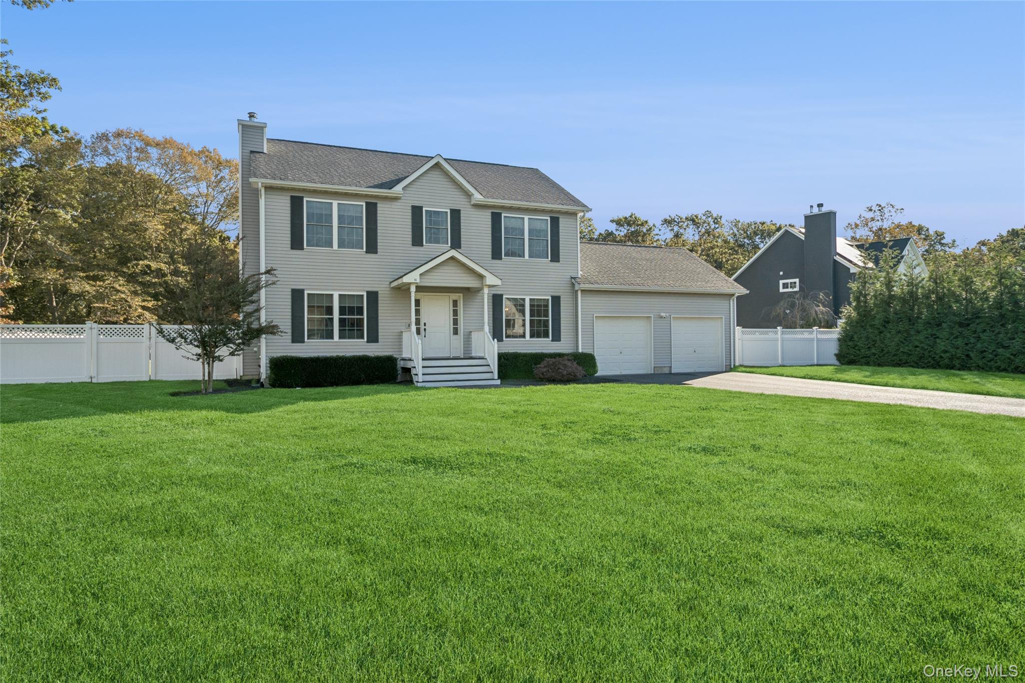 a front view of a house with a garden and yard