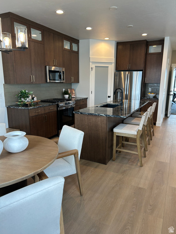 2011 West 1150 South, Unit 1042 Payson, UT 84651 - Photo 15 of 39 Photos are of model home.Contemporary kitchen featuring dark wood-finish cabinetry, stainless steel appliances, and an expansive island with a built-in sink