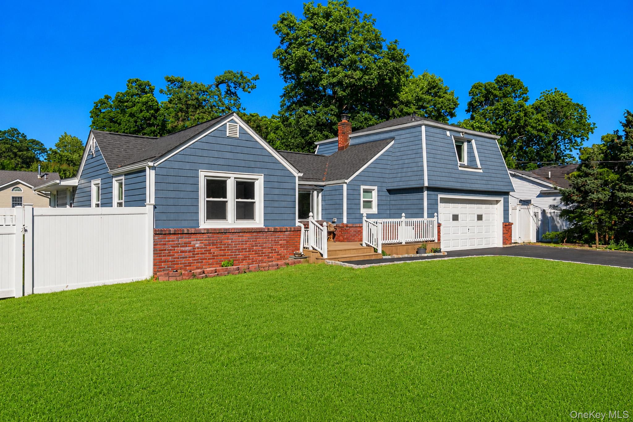 33 Lillian Road Nesconset, NY 11767 - Photo 2 of 42 Wonderful Curb Appeal On Beautifully Manicured Fully PVC Fenced Corner Property With A Four Year Old Architectural Roof & Vinyl Siding, Brick Front Trim/Facade & Large Composite/Trex Front Porch With PVC Railings.