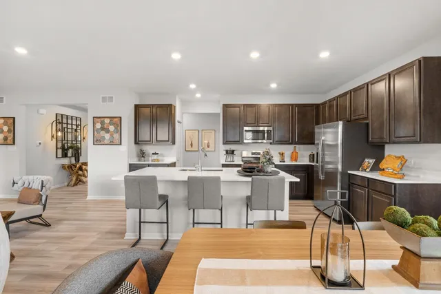 a kitchen with stainless steel appliances kitchen island granite countertop a refrigerator and cabinets