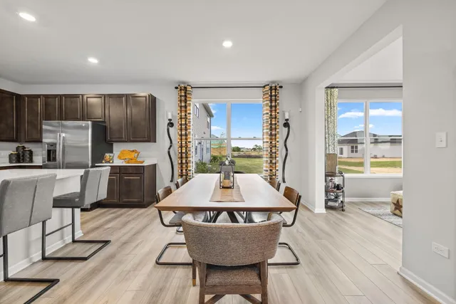 a room with wooden floor table and chairs