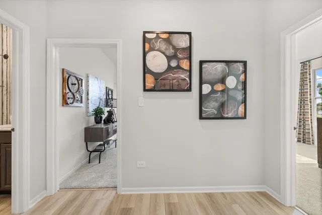 wooden floor with table and paintings on wall