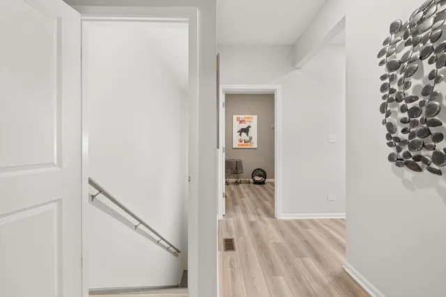 a view of a room with wooden floor staircase and a hallway