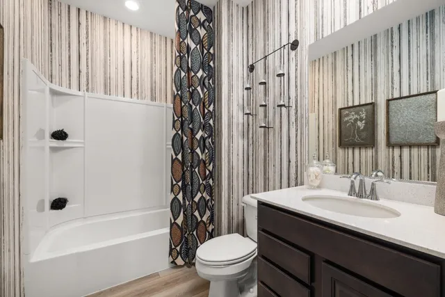 a bathroom with a sink a toilet and shower curtain