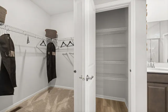 a view of walk in closet with clothes and shoes