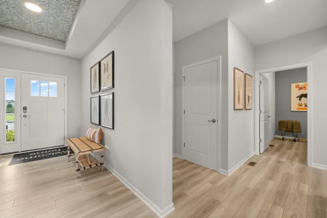 a view of a hallway with wooden floor and furniture and a living room