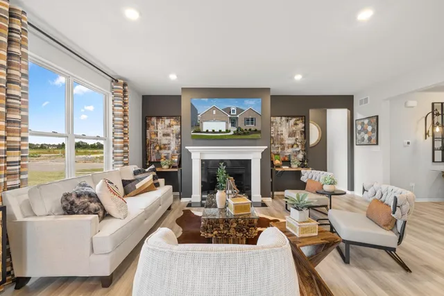 a living room with furniture fireplace and a large window