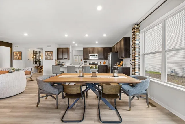 a dining room with stainless steel appliances kitchen island granite countertop a dining table chairs and view of kitchen