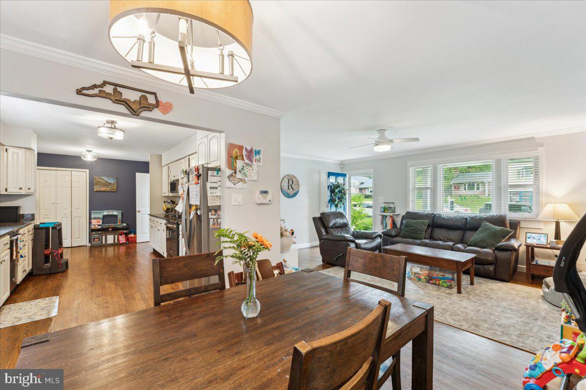 5222 Ferndale Street Springfield, VA 22151 - Photo 5 of 33 a living room with furniture a chandelier a dining table and wooden floors
