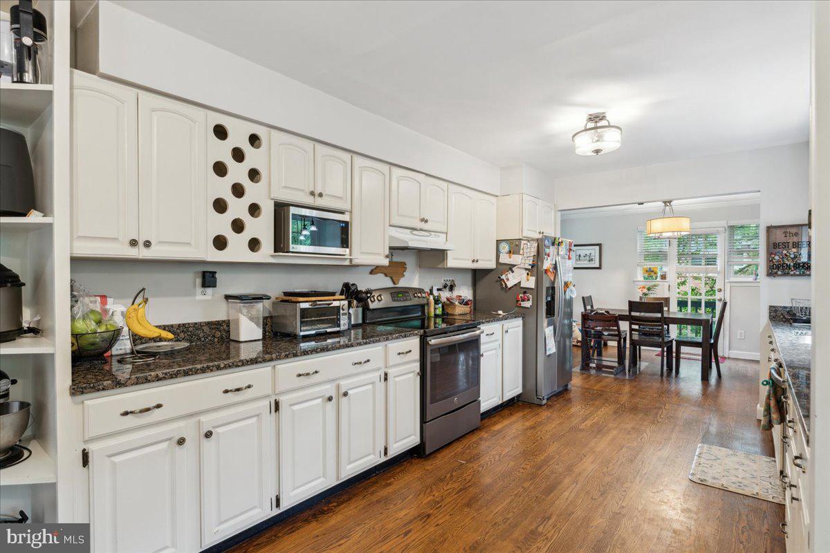 5222 Ferndale Street Springfield, VA 22151 - Photo 7 of 33 a kitchen with stainless steel appliances granite countertop a refrigerator a stove a sink dishwasher and white cabinets with wooden floor