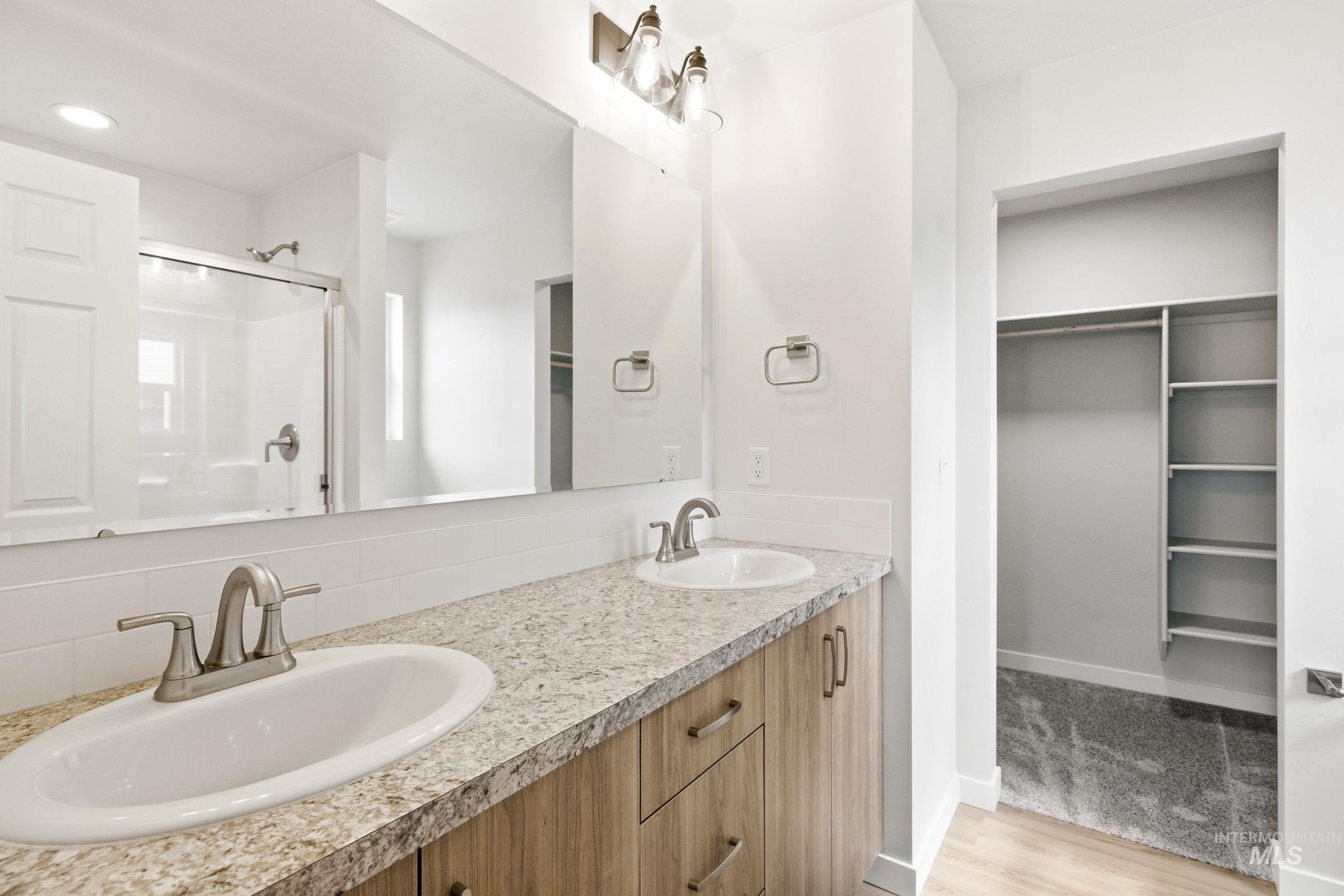 13735 Inman Court Caldwell, ID 83607 - Photo 16 of 20 Bathroom featuring a spacious closet, a shower stall, double vanity, and light wood-type flooring