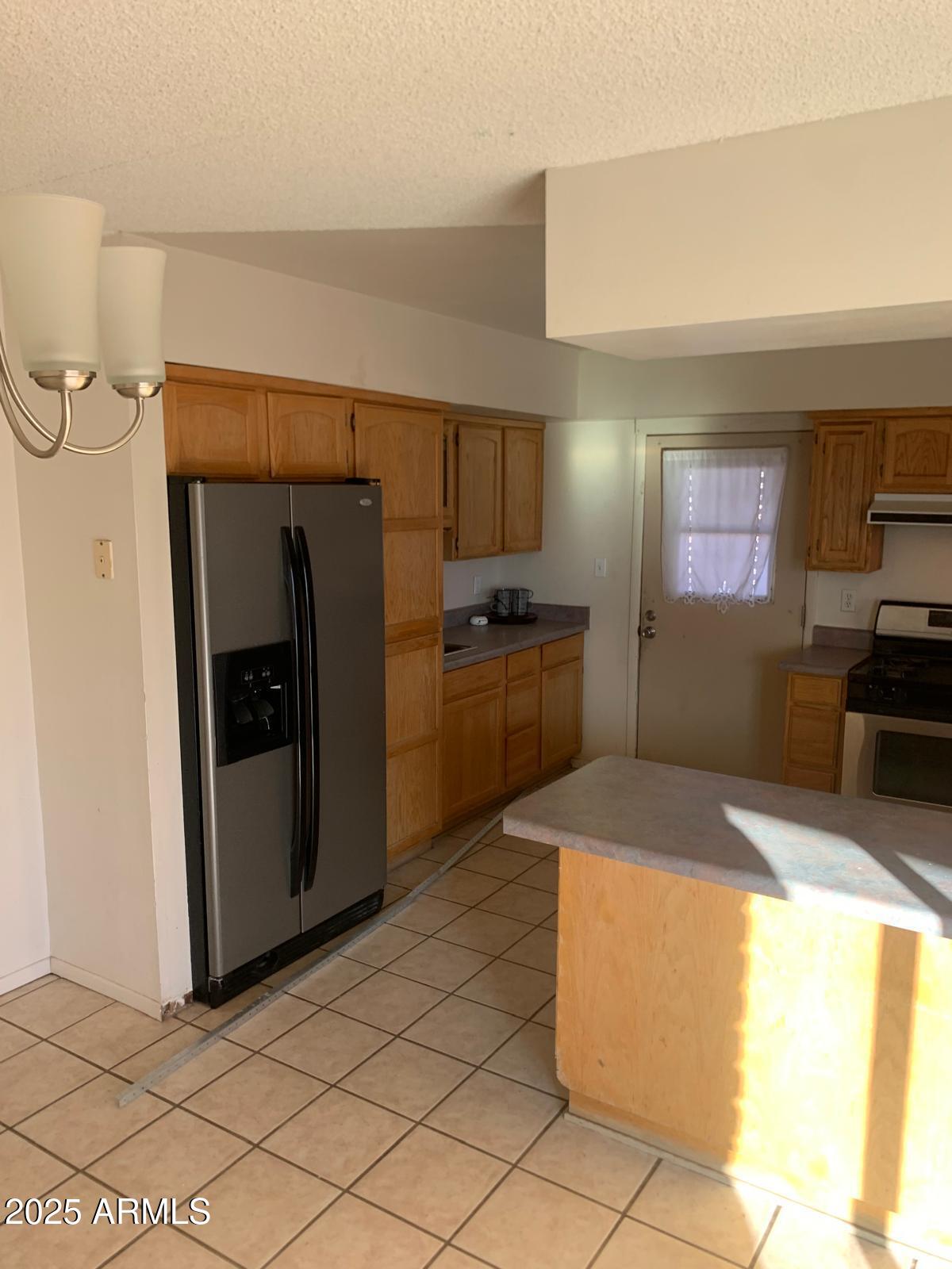 2419 East 10th Street Douglas, AZ 85607 - Photo 3 of 14 a kitchen with stainless steel appliances granite countertop a refrigerator and a stove