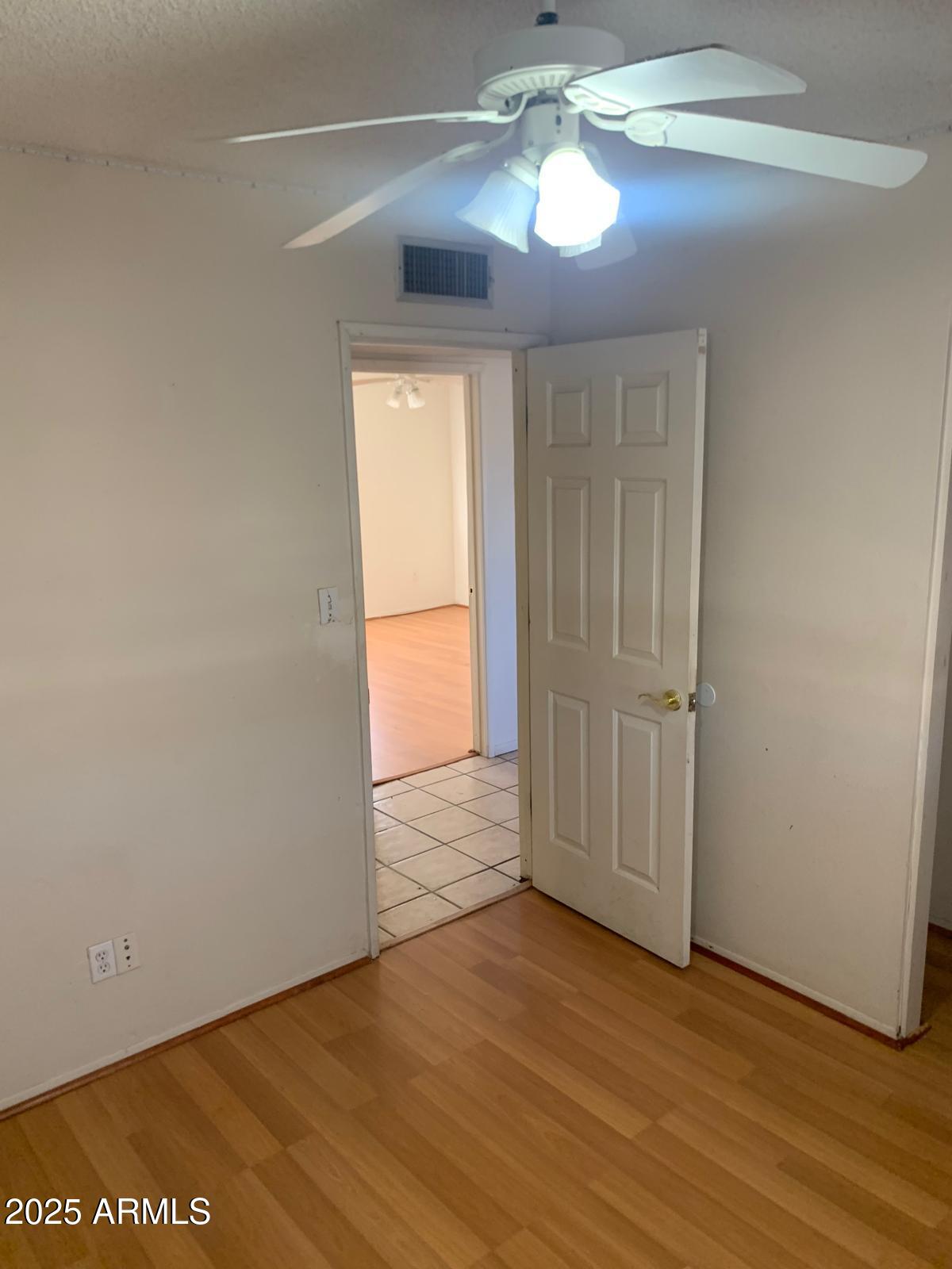 2419 East 10th Street Douglas, AZ 85607 - Photo 5 of 14 an empty room with wooden floor chandelier fan and windows