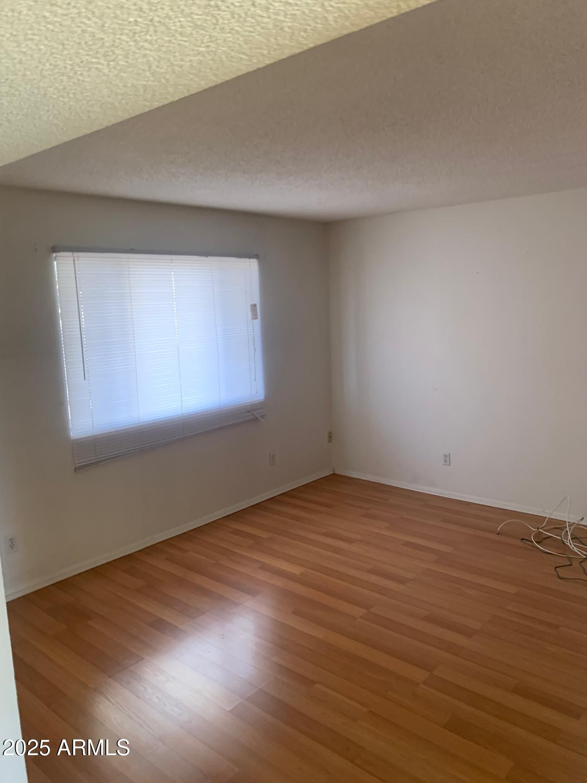2419 East 10th Street Douglas, AZ 85607 - Photo 9 of 14 an empty room with wooden floor and windows