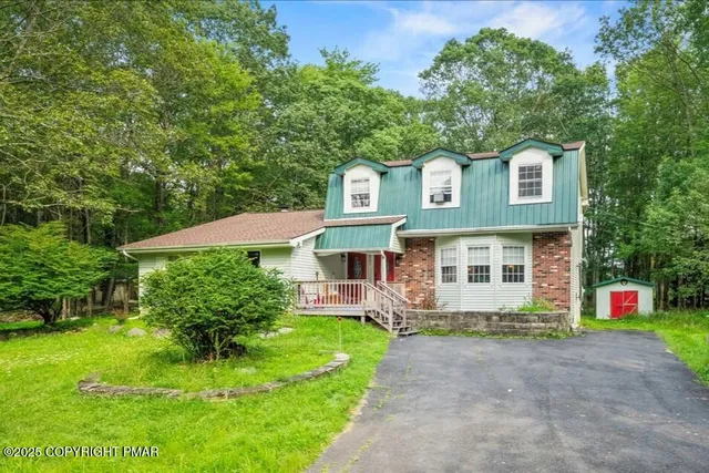 a front view of a house with a yard and potted plants