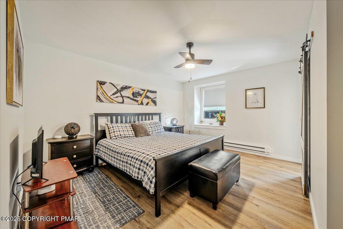 2102 Woodland Court Pocono Summit, PA 18346 - Photo 21 of 42 a bedroom with a bed and wooden floor