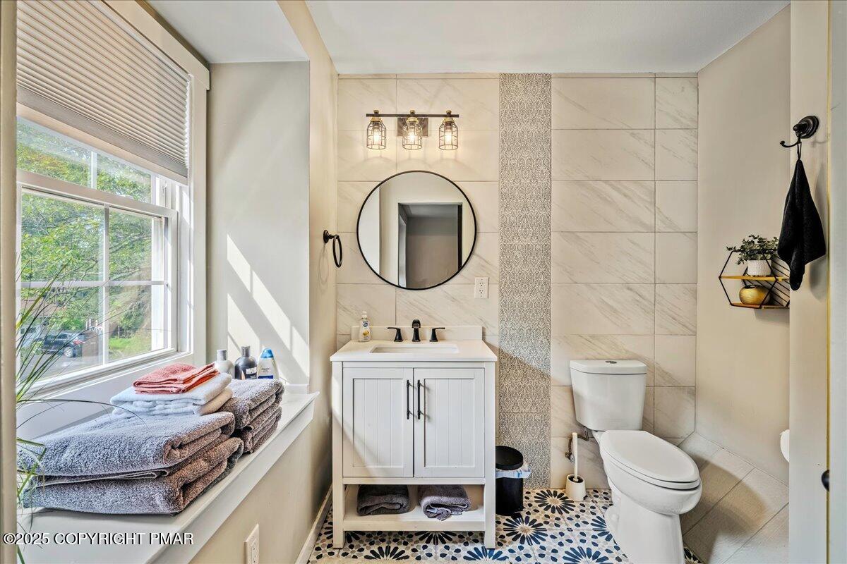 2102 Woodland Court Pocono Summit, PA 18346 - Photo 23 of 42 a bathroom with a granite countertop toilet sink and mirror