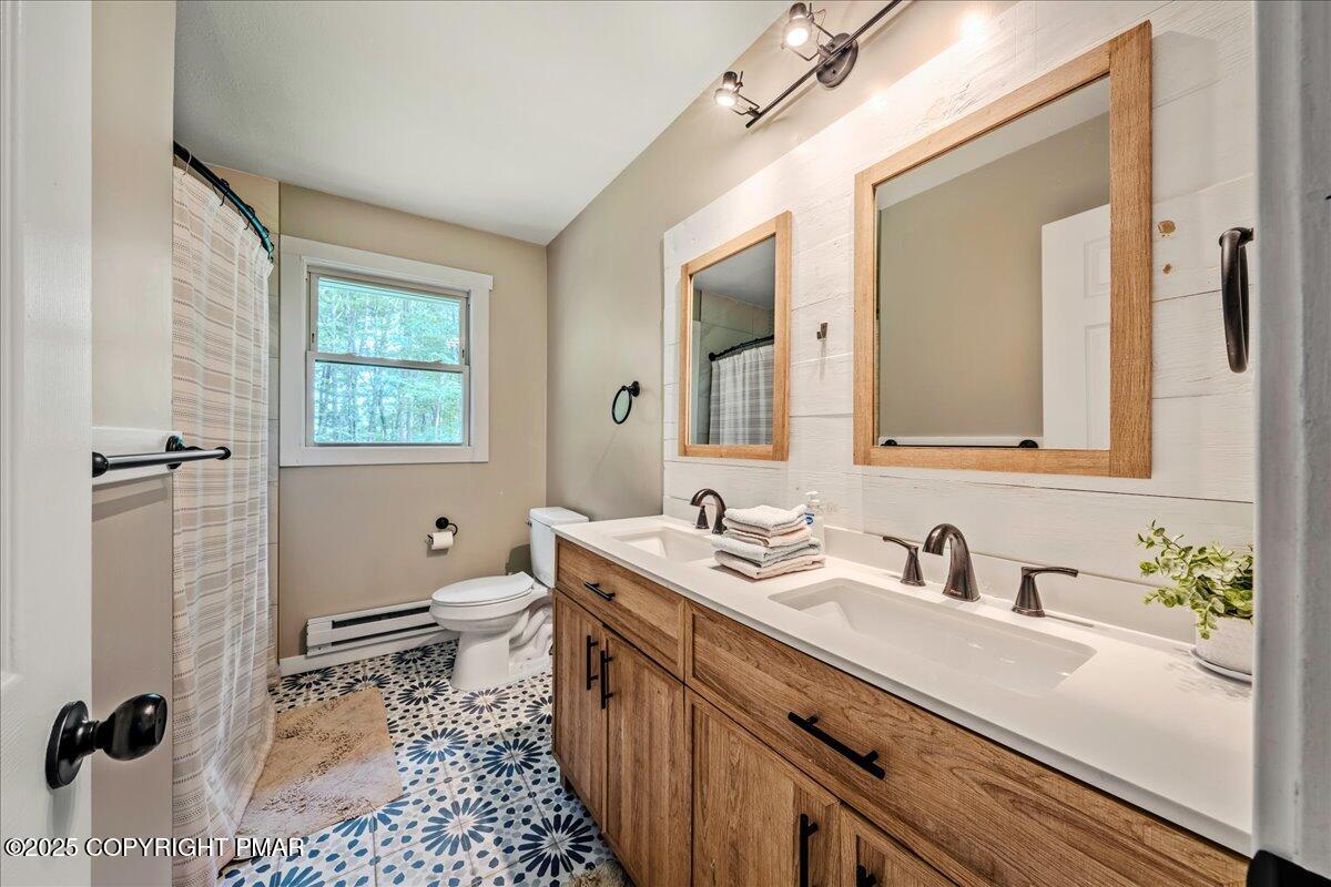 2102 Woodland Court Pocono Summit, PA 18346 - Photo 31 of 42 a bathroom with a sink a toilet a mirror and shower