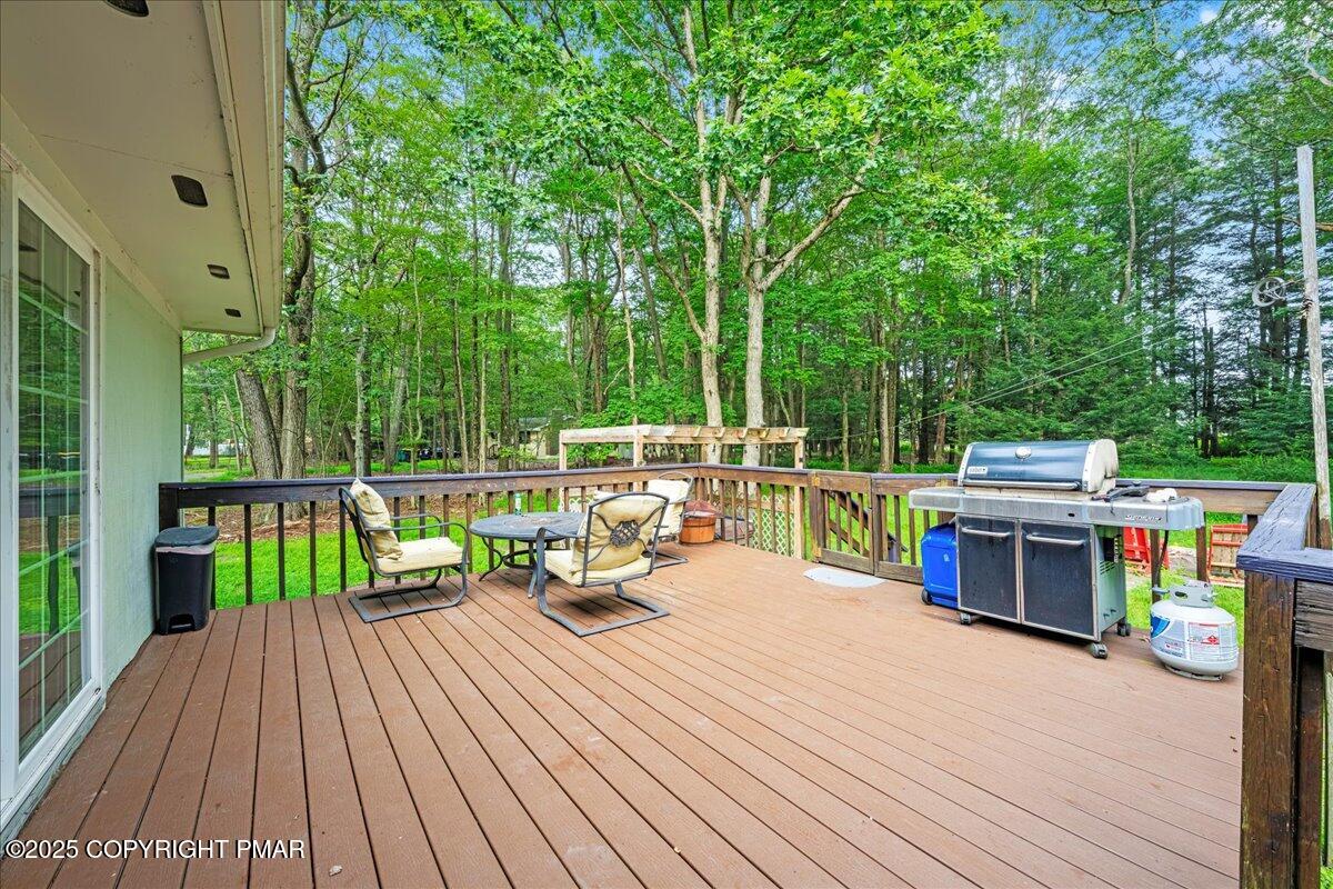 2102 Woodland Court Pocono Summit, PA 18346 - Photo 35 of 42 a view of a deck with chairs a barbeque with wooden floor and fence