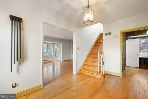 a view of a livingroom with wooden floor and stairs