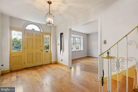 a view of a livingroom with wooden floor and a fireplace