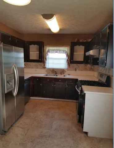 a kitchen with stainless steel appliances granite countertop a sink and a stove