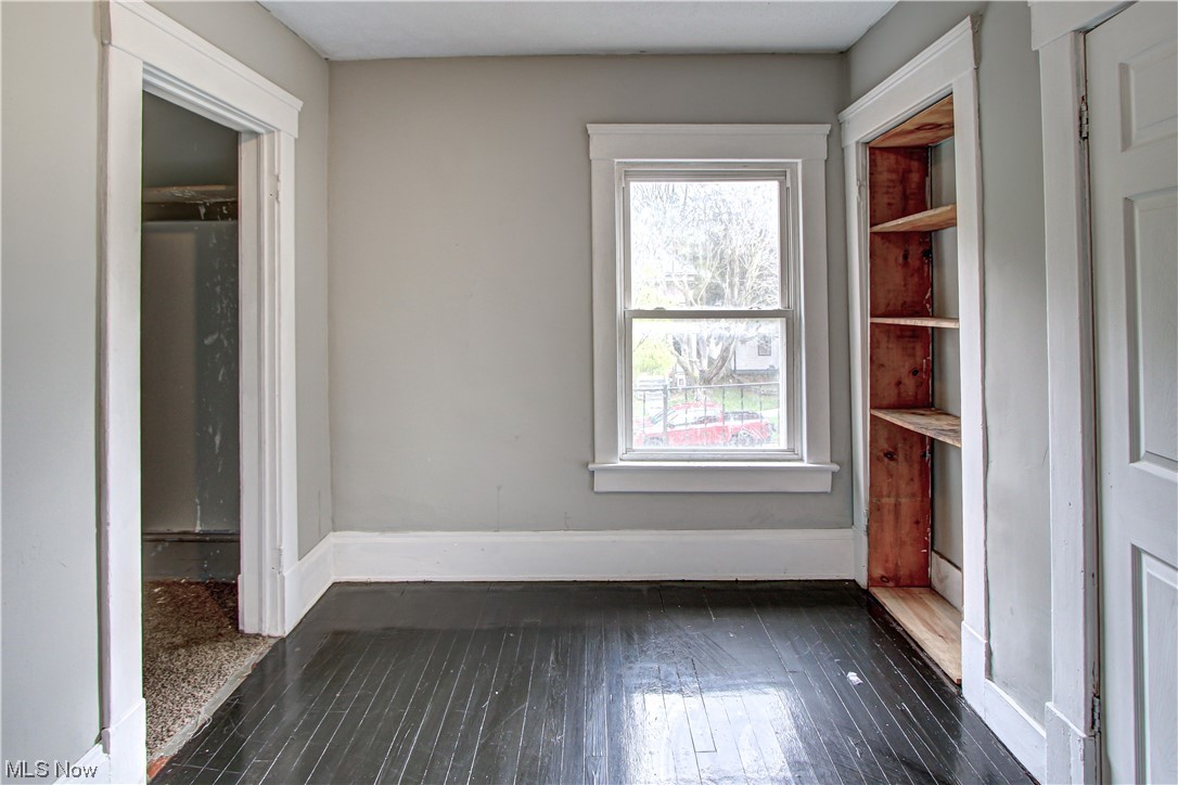 3816 Riverside Avenue Cleveland, OH 44109 - Photo 10 of 35 Empty room featuring a wealth of natural light and dark hardwood flooring