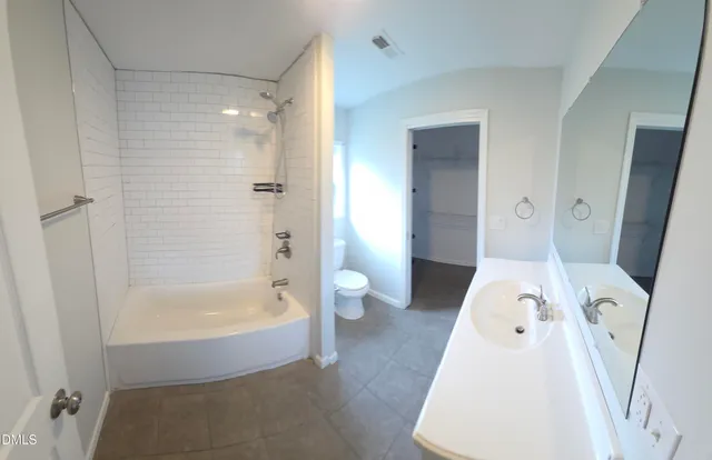 a bathroom with a tub shower and toilet