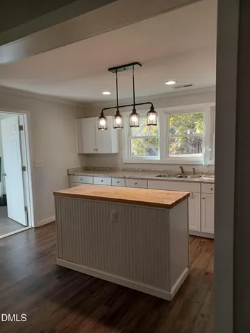 a view of a kitchen counter space a sink wooden floor and window