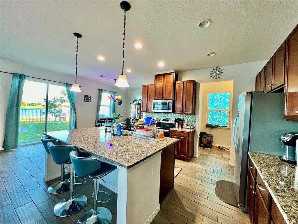 14112 Poke Ridge Drive Riverview, FL 33579 - Photo 11 of 46 a kitchen with a stove a kitchen island a table and chairs in it